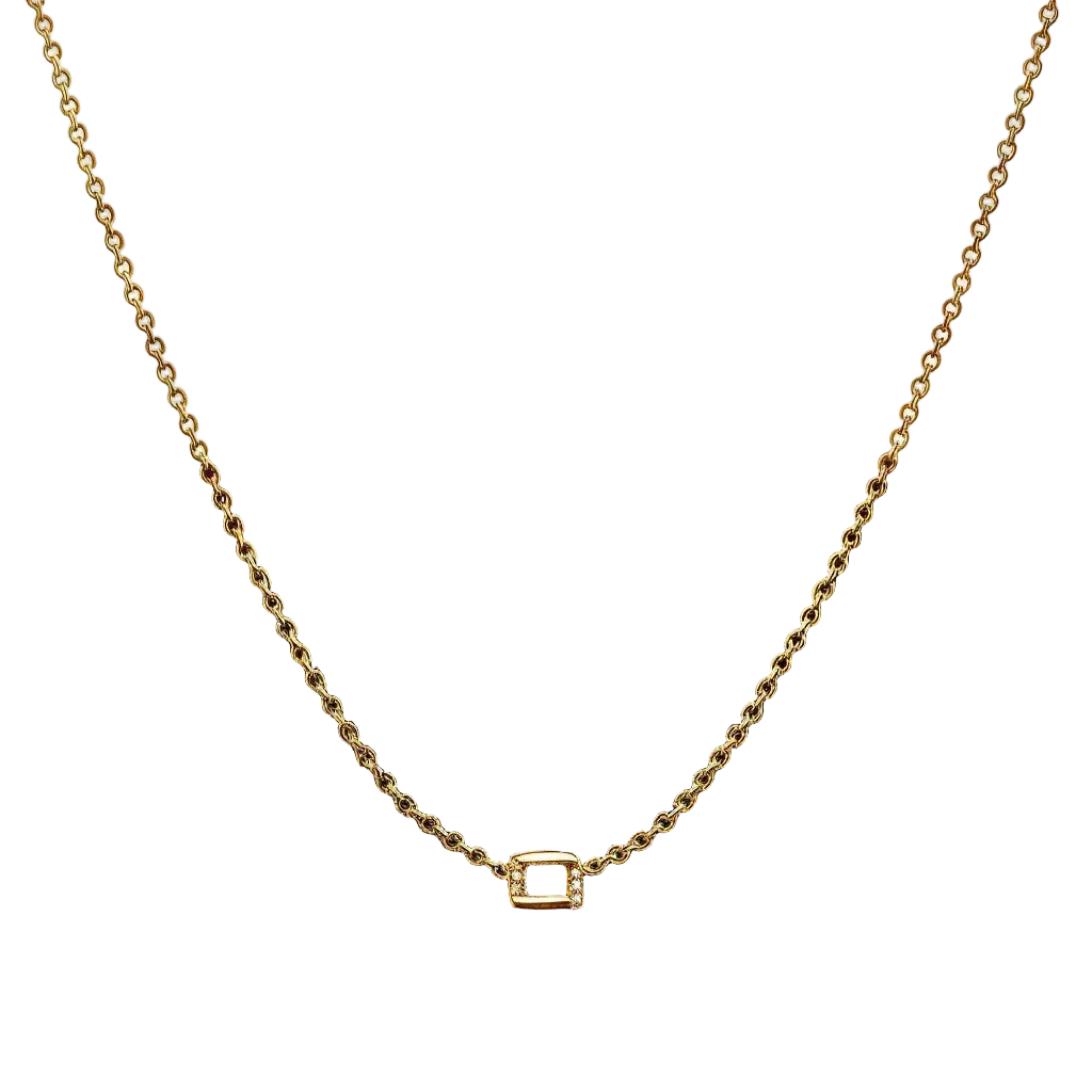 Gold necklace with a small square pendant on a dark surface
