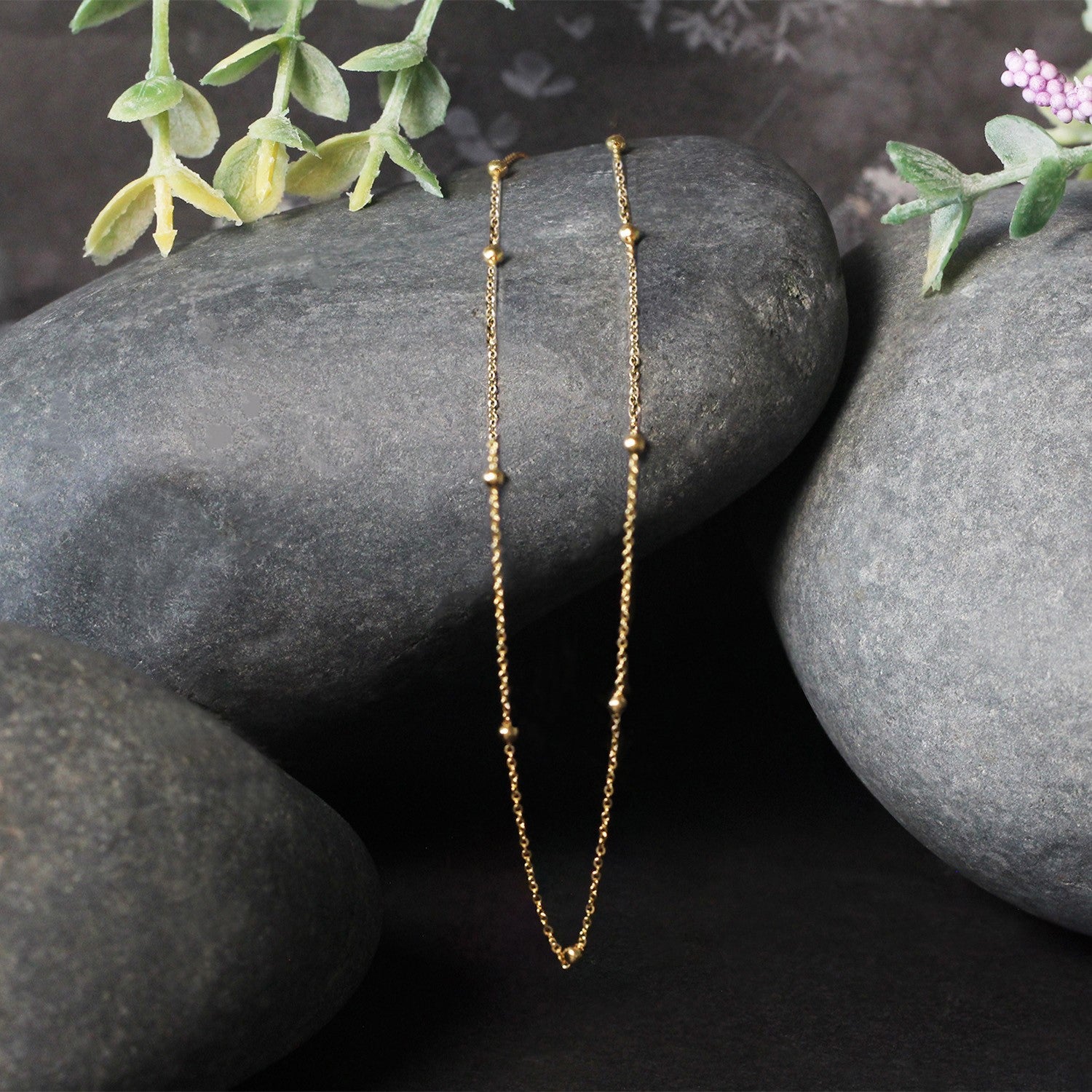 Bead Links Saturn Chain in 14k Yellow Gold (1.80 mm) in a sleek high-contrast midnight luxury editorial style