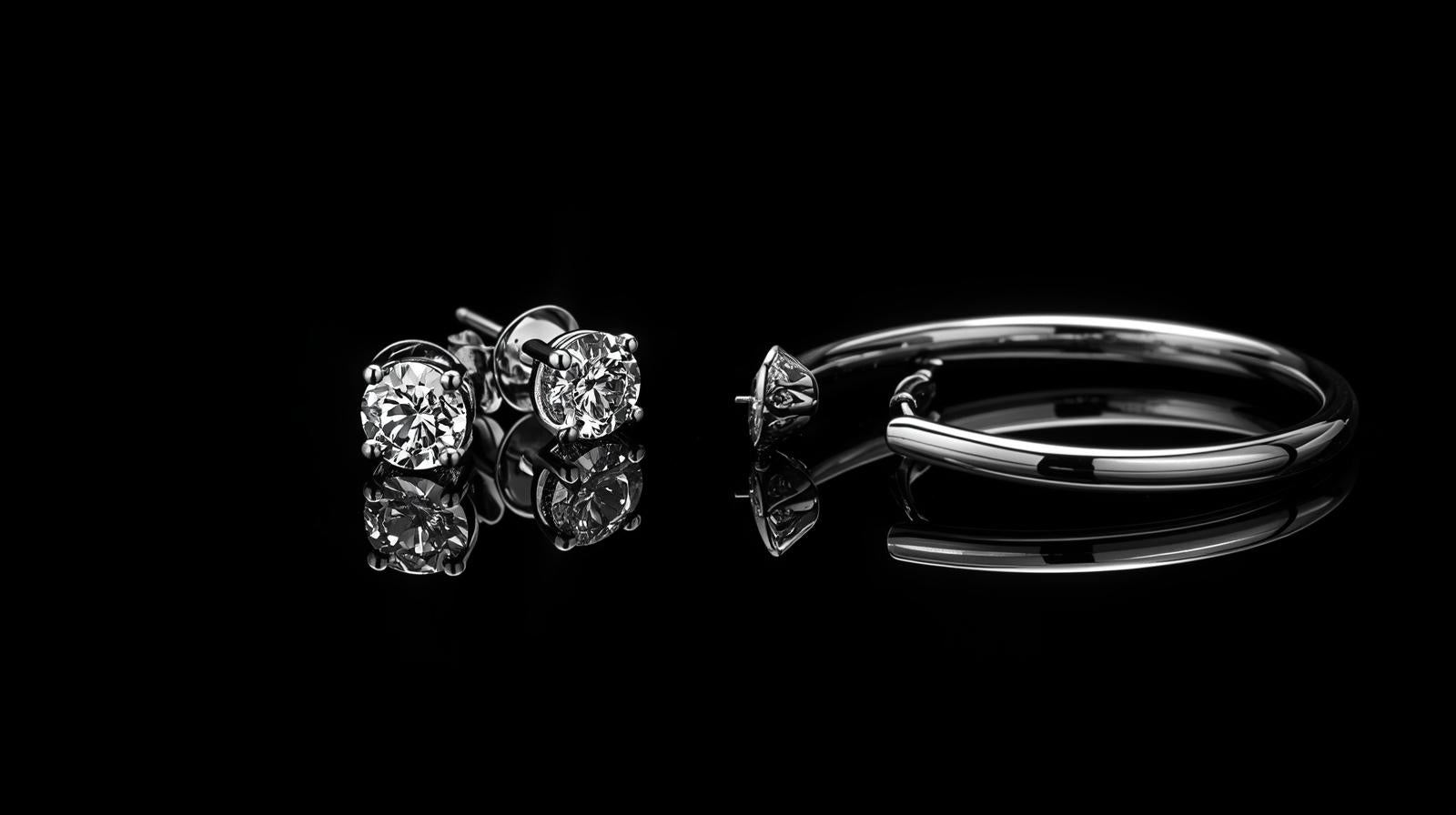 Silver ring and earrings on a black background