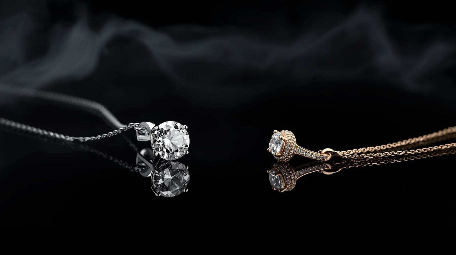 Two diamond necklaces on a reflective black surface with a dark background