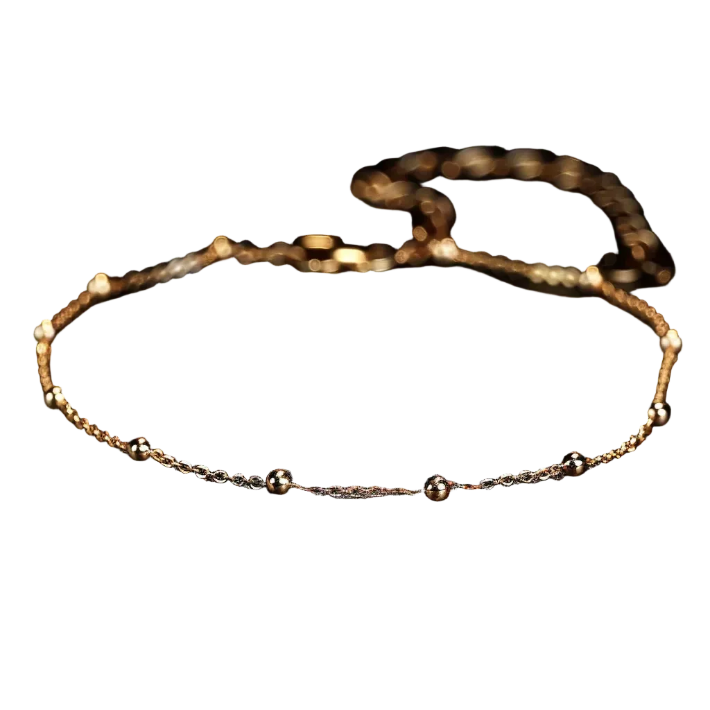 Gold anklet on a dark surface