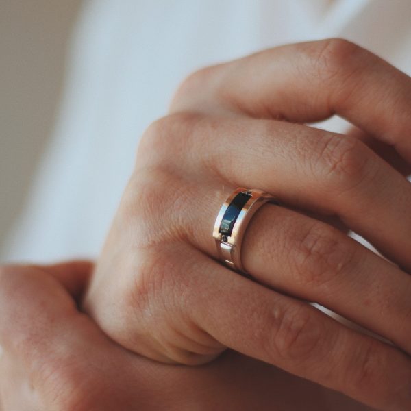 A closeup shot of a male in a formal outfit wearing a golden ring